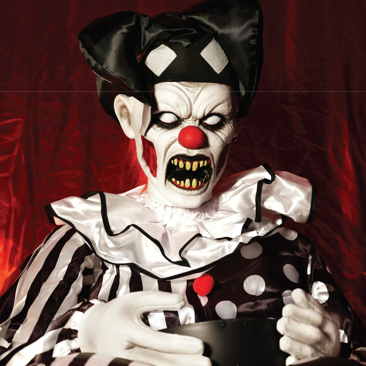 Close up of the clown face with white eyes and yellow teeth